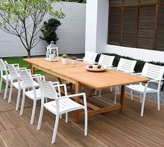 a wooden table with white chairs on top of it