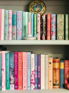 books are lined up on the shelves in a room with a clock and other items