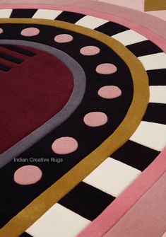 an area rug is shown with pink, black, and white circles on it's center