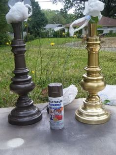 two brass candlesticks with white flowers on them and some spray paint next to them