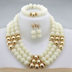 a white and gold beaded necklace with matching earrings