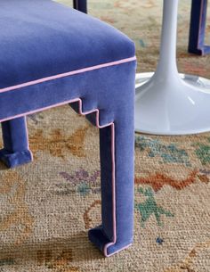 an upholstered blue chair with pink piping