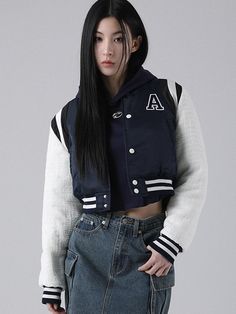 a woman with long black hair wearing a jacket and skirt