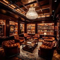 a living room filled with brown leather furniture and a chandelier hanging from the ceiling