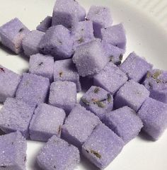 purple sugar cubes are on a white plate