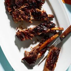 barbecue ribs on a white plate with tongs