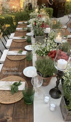 a long table is set with place settings and flowers