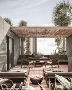 an outdoor living area with wicker furniture and palm trees