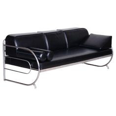 a black leather couch with chrome legs and arm rests on a white background, it appears to be empty