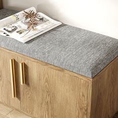 a wooden bench with a newspaper on top of it and a plant in the middle