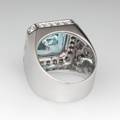 This captivating ring is centered with one (1) square emerald cut natural aquamarine set into a four-prong setting. The top and side faces of the ring are accented with forty-eight (48), prong set, round brilliant cut diamonds. The ring measures 18.0mm at the top, rises 7.7mm above the finger, tapering to 7.8mm wide and 0.7mm thick at the base of the shank. This ring is currently a size 7. The aquamarine shows moderate nicks and abrasions. Luxury Formal Emerald Ring With Radiant Cut, Rectangular Emerald Ring With Accent Stones For Formal Events, Rectangular Emerald Ring With Accent Stones For Formal Occasions, Luxury Rectangular Emerald Ring With Center Stone, Luxury Aquamarine Octagon Ring, Luxury Octagon Aquamarine Ring, Luxury Aquamarine Diamond Ring With Prong Setting, Luxury Blue Topaz Ring With Polished Finish, Luxury Topaz Ring Emerald Cut With Vvs Clarity