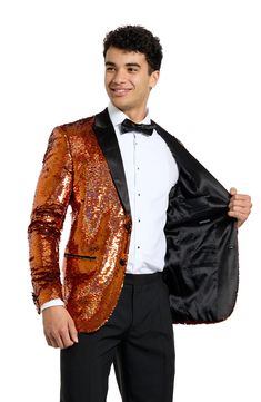 Drenched in golden sequins and finished with satin lapels, the jacket of this entrance-making tuxedo pairs with pleated black trousers and a coordinating bow tie to finish the standout look. Jacket has peaked lapels; four-button cuffs; chest pocket; welt pockets; interior pockets; side vents Trousers have zip fly with button-tab closure; slant pockets; back pockets Jacket is lined Unhemmed 100% polyester Machine wash, line dry Imported Fitted Sequined Suits For Parties, Gold Fitted Tuxedo For Formal Occasions, Glamorous Sequined Suits For Night Out, Festive Fitted Gold Tuxedo, Festive Gold Fitted Tuxedo, Gold Festive Evening Suit, Gold Notch Lapel Outerwear For Evening, Sequined Long Sleeve Suits For Night Out, Sequined Long Sleeve Suit For Night Out