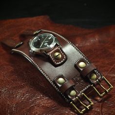 "This brown leather cuff watch is made using top quality full grain bridle leather. It is 2.5\" wide and handstitched in offwhite thread around the edges. The watchtabs are also handstitched and closes with aged brass roller buckles. A classic FM watch with polished stainless case and a black face and water resistant movement sits atop! I'll need your wrist size for this watch. Please use the instructions above! It can be sized for guys or girls! - 2.5\" wide - Full grain bridle leather - FM watchface with 316L stainless case, sapphire crystal, japan quartz movement and water resistance - Available with aged nickel harware; just ask! Thanks for checking out my work! I use a fine hand in my work bridging the gap between craft and art and truly love making You leather wristwear.  Thanks! Fre Vintage Brown Leather Strap Watch Accessories, Adjustable Steampunk Brown Watch, Vintage Cuff Watch With Leather Strap, Brown Leather Strap Cuff Watch, Distressed Brown Leather Strap For Watch, Cuff Watch, Leather Cuffs, Aged Brass, The Gap