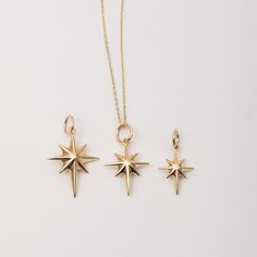 three gold star pendants on a white background