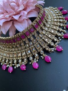 This choker is sure to be a complete statement look for your next event! made with gorgeous polki stones with antique gold finish and a pop of color with pink/purple beads, this choker is sure to be the perfect addition for your next occasion! comes with matching earrings and tikka! Pink Kundan Tikka For Parties, Pink Kundan Necklace With Tilla For Festivals, Pink Kundan Bridal Necklace For Party, Festive Pink Kundan Necklace With Tilla, Pink Kundan Necklace With Tilla Detail, Pink Kundan Necklace With Tilla, Pink Kundan Necklace With Stone Work For Party, Pink Kundan Choker For Festivals, Festive Pink Kundan Necklace With Stone Work