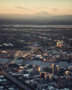 an aerial view of a city with mountains in the background and a river running through it