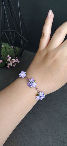 a woman's hand with purple flowers on it