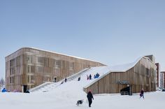 people are walking up and down the snow covered stairs in front of a wooden building