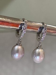 These are the earrings Kate Middleton Wears casually, We replicate them in detail, from pearl shape & size They are made of natural gray Pearl (akoya) with Melee Sized Diamonds Sterling Setting. 925 Stamp setting. Exceptional quality pearl with beautiful luster and brilliant nacre. You can see reflection off the pearl. We also pay attention to detail. Like Kate's earrings... You will also notice there's no hole on the bottom of the pearl, (no posts stick out of bottom like you see on many lo Silver Akoya Pearl Dangle Earrings, Classic Tahitian Pearl Earrings For Anniversary, Fine Jewelry Silver Akoya Pearl Earrings, Luxury Oval Pearl Drop Earrings, Silver Akoya Pearl Drop Earrings, Elegant Silver Oval Pearl Earrings, Elegant Silver Diamond Earrings With Pearl Drop, Silver Diamond Earrings With Pear Accents, White Gold Diamond Earrings With Pearl Charm