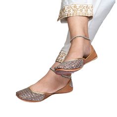 Step into timeless elegance with our "Juno" Punjabi jutti, a true masterpiece meticulously crafted by skilled artisans using pure leather. This exquisite footwear exudes sophistication with its stunning beige color, beautifully complemented by thick silver jari work adorning the upper. Every detail of the "Juno" jutti speaks of unparalleled craftsmanship, with each stitch lovingly placed by hand to ensure impeccable quality. The intricate silver jari work adds a touch of glamour, making it the perfect accessory to elevate any ethnic ensemble. Wearing the "Juno" jutti not only enhances your look but also reflects your stylish personality and appreciation for timeless fashion. Whether you're attending a wedding, festival, or any special occasion, this jutti is sure to make a statement and se Leather Wedding Flats With Leather Sole, Leather Flats With Leather Sole For Wedding, Leather Flats For Wedding, Festive Sandals With Gota Work And Single Toe Strap, Leather Flats For Wedding And Festive Occasions, Traditional Sandals With Zari Work For Festive Occasions, Traditional Festive Sandals With Zari Work, Festive Diwali Slip-on Sandals, Festive Closed Toe Sandals With Gota Work