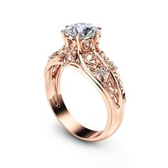 a rose gold engagement ring with an intricate filigreet design on the side