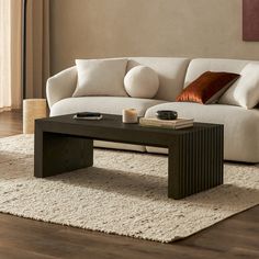 a living room with a couch, coffee table and rugs on the hardwood floor