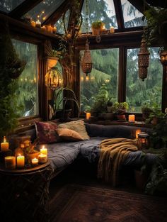 a living room filled with lots of plants and candles on top of a couch next to a window