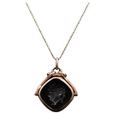 Transport yourself to the captivating era of Victorian Revival with this remarkable mid-century Intaglio locket necklace. This exquisite piece features a 14k gold pendant adorned with an intricate intaglio design, suspended from a 10k gold chain. It encapsulates the charm and elegance of the Victorian era, revitalized for the mid-20th century. The pendant of the necklace is crafted from 14k gold, radiating a warm and luxurious glow. Its surface showcases a meticulously carved intaglio design, a technique that involves incising a pattern or image into the gemstone. This intricate detailing captures the essence of Victorian aesthetics, with motifs such as floral patterns, classical figures, or mythological symbols commonly depicted. The intaglio pendant is designed to hold a cherished keepsa Unique Locket Necklace 1stdibs, Luxury Victorian Style Pendant Locket Necklace, Mythological Symbols, 10k Gold Chain, Victorian Revival, Miniature Portraits, Gold Locket, Locket Necklace, Victorian Era