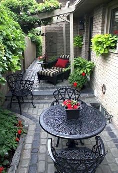 an outdoor patio with chairs, table and potted plants