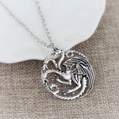 a silver necklace with a dragon on it