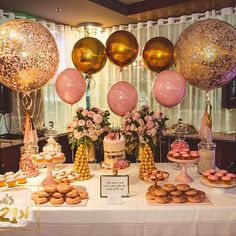 a table topped with lots of desserts and balloons