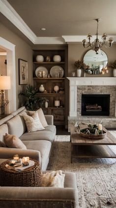 a living room filled with furniture and a fire place under a mirror on the wall