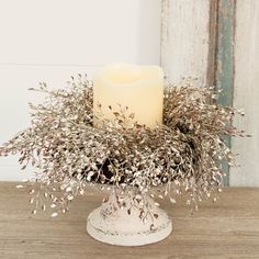 a white candle sitting on top of a wooden table