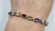 This is a beautiful sterling silver bracelet set with twenty 6mm by 4mm oval real gemstones. There are four garnets, four peridots, four amethyst, four aquamarines, and four citrines. The bracelet fits a 7 inch wrist and is stamped with 925 and China. Sterling Silver Oval Gemstone Bracelet For Anniversary, Oval Sterling Silver Bracelet With Gemstone For Anniversary, Oval Gemstone Bracelets For Anniversary, Oval Multicolor Jewelry For Formal Occasions, Elegant Gemstones With Birthstone, Oval Gemstone Accent Bracelets For Anniversary, Oval Bracelets With Gemstone Accents For Anniversary, Formal Oval Bracelets With Birthstone, Oval Anniversary Bracelets With Gemstone Accents