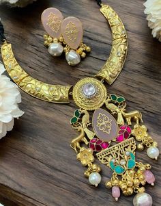 Sabyasachi Inspired Polki Hasli Necklace, featuring a long Kundan pendant in gold-plated fusion. Ideal for blending traditional and contemporary vibes, pair it with a modern saree or fusion outfit. Keep your makeup dewy and your hairstyle sleek to ensure the necklace remains the statement piece. *𝐏𝐑𝐎𝐃𝐔𝐂𝐓 𝐃𝐄𝐓𝐀𝐈𝐋* * Material: Brass * Plating: Gold Plated. * Stone: Semi Precious Carved Stones, Kundan, Polki *𝐃𝐈𝐒𝐂𝐋𝐀𝐈𝐌𝐄𝐑* Product color may slightly vary due to photographic ligh Gold Kundan Pendant Temple Necklace, Gold Plated Chandbali Necklaces For Festivals, Gold Temple Jewelry Necklace With Meenakari, Gold Kundan Chandbali Necklace, Gold Plated Chandbali Necklaces For Celebration, Gold Plated Chandbali Necklace For Celebrations, Gold Plated Meenakari Necklaces, Festive Kundan Gold Necklaces, Gold Pendant Kundan Necklace For Celebration