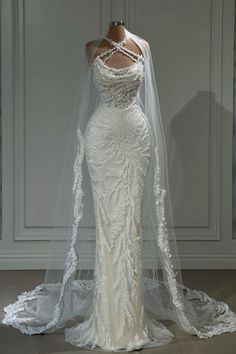 a white wedding dress with long veil on display