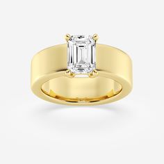 a yellow gold ring with an emerald cut diamond