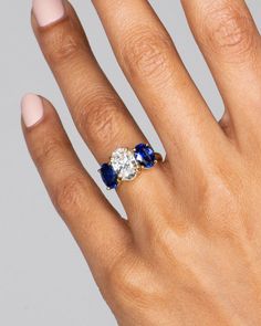 a woman's hand with a diamond and sapphire ring