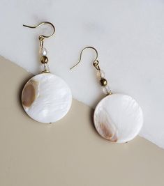 Solazur earrings "Shella" --- Beautiful. Different. Feminine elegance. These earrings will add a pop of style and a boho breeze to your outfit. Seashells are the best summer and beach reminder, and wearing them will make you feel you're on vacation every day :-)  A blend of shell and glass, with an intricate glass shine while the shell's texture reflects its pearly glow from different angles.  The shell coins have a different pattern on each side. They will match beautiful with either a dress or Bohemian Shell Earrings For Gift, Elegant Nickel-free Beach Earrings, Elegant Nickel-free Earrings For The Beach, Pearl Drop Shell As A Gift, Bohemian Round Earrings For The Beach, Bohemian Shell-shaped Earrings For Gift, Elegant Handmade Shell Jewelry, Bohemian Mother Of Pearl Drop Earrings, Bohemian Mother Of Pearl Shell Gift