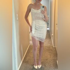 a woman in a white dress taking a selfie