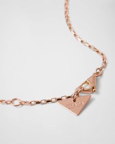 750 Pink Gold (18 kt) Triangle pendant: 1.3 cm (0.51 inches) Lobster claw clasp with logo-engraved medal Length: 45 cm (17.71 inches) adjustable to 43 cm (16.92 inches) and 41 cm (16.14 inches) Made in Italy Each step of Prada's responsible gold and diamond production chain is verified and traceable thanks to Aura Blockchain technology. Luxury Gold-tone Jewelry With Logo Charm, Gold-tone Logo Plaque Pendant Necklace As Gift, Gift Necklace With Gold-tone Logo Pendant, Gold-tone Pendant Necklace As A Gift, Gold-tone Logo Plaque Pendant Necklace, Formal Gold-tone Necklace With Logo Plaque, Yellow Gold Pendant Jewelry With Gold-tone Logo Plaque, Classic Gold-tone Logo Plaque Necklace, Elegant Gold-tone Logo Plaque Pendant Jewelry