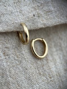 These are great classic little huggie hoops made in solid 9ct yellow gold.  They are oval in shape which keeps them hugging closer to the ear.  The perfect way to bring a bit of warm gold into a cureated ear look although they also make enough impact to be worn alone.   They are 6mm by 10mm across internally and 2mm wide.  I have a variety of huggies and hoops available on my page please check out my other listings.  If you require more of this item than is showing as available to purchase pleas Classic Huggie 14k Gold Rings, Classic 14k Gold Huggie Rings, Classic Small Hoop Rings For Everyday, Tiny Classic Hoop Earrings, 14k Gold Huggie Rings For Everyday, Tiny Gold Huggie Earrings Simple Style, Everyday 14k Gold Huggie Rings, Simple Tiny Gold Huggie Earrings, Simple Tiny Huggie Earrings