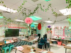 a classroom filled with desks and chairs covered in green ivy hanging from the ceiling