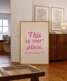 this is our place we make the rules poster in front of a wooden table with two framed pictures on it