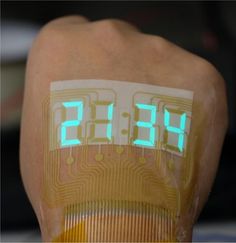 an electronic clock on the back of a person's arm with glowing green numbers