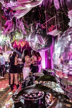 a group of people that are standing in front of some disco balls and plates with food on them