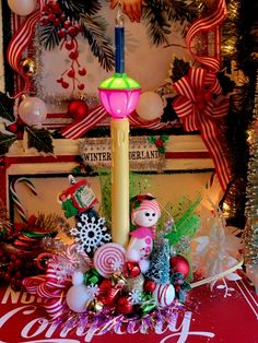 a lighted candle surrounded by christmas decorations and candy canes in front of a holiday display