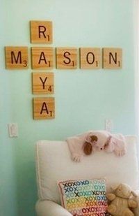 a baby's room with scrabble tiles on the wall and teddy bear