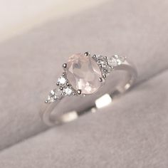 * The delicate ring displays pink quartz as main stone. The cluster side stones make the ring similar to the blooming flower . For who wearing this special & delicate ring, will shine like a goddess. ◆ Production Description: Main stone Type: Pink Quartz Main Stone Shape: Oval Cut Main Stone Size: 6*8mm (1.14ct) Side stone: CZ Metal: 925 Sterling silver - Other options available in the drop down menu ◆ Customization: √Free for Add Engraving √Other Metal Type Available √Other Gemstones & Rose Quartz Engagement Ring Silver, Pink Crystal Ring With Center Stone For Wedding, Pink Crystal Wedding Ring With Center Stone, Pink Crystal Ring For Wedding, Fine Jewelry, Fine Jewelry Pink Crystal Wedding Ring, Pink Fine Jewelry Crystal Ring For Wedding, Feminine Rose Quartz Wedding Jewelry, Promise Ring With Rose Quartz And Gemstone Detail, Delicate Oval Crystal Promise Ring