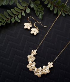 Gold plumeria flower jewelry set - plumeria necklace, plumeria earrings, Hawaii jewelry, plumeria lei necklace, feminine jewelry, delicate jewelry, dainty jewelry, bridesmaids gift idea, wedding jewelryThis beautiful jewelry set features gold plated plumeria flowers suspended on a delicate 14K gold filled chain, and a set of  matching single plumeria flowers earrings.   A lovely jewelry set that reminds me of Hawaii.Dimension:----------------Plumeria lei: 3 inchesTotal necklace length: 17 inches Plumeria Necklace, Plumeria Lei, Hawaii Necklace, Dainty Jewelry Necklace, Flower Lei, Hawaii Jewelry, Idea Wedding, Flowers Earrings, Feminine Jewelry